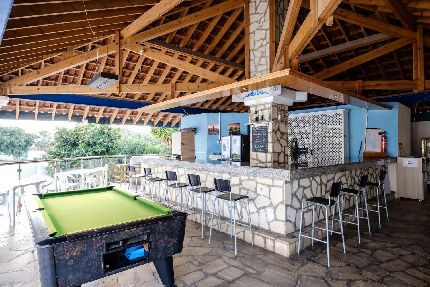 Pool bar with a pool table under a wooden roof